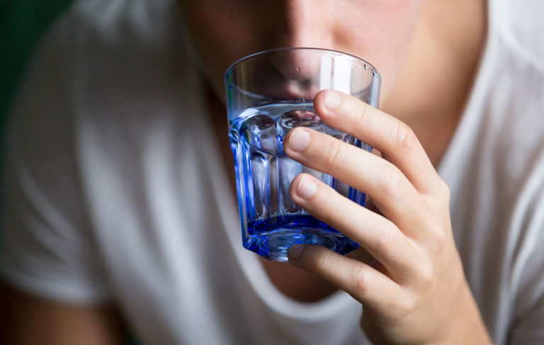 leczenie uzależnień alkoholowych mężczyzna pije z niebieskiej szklanki